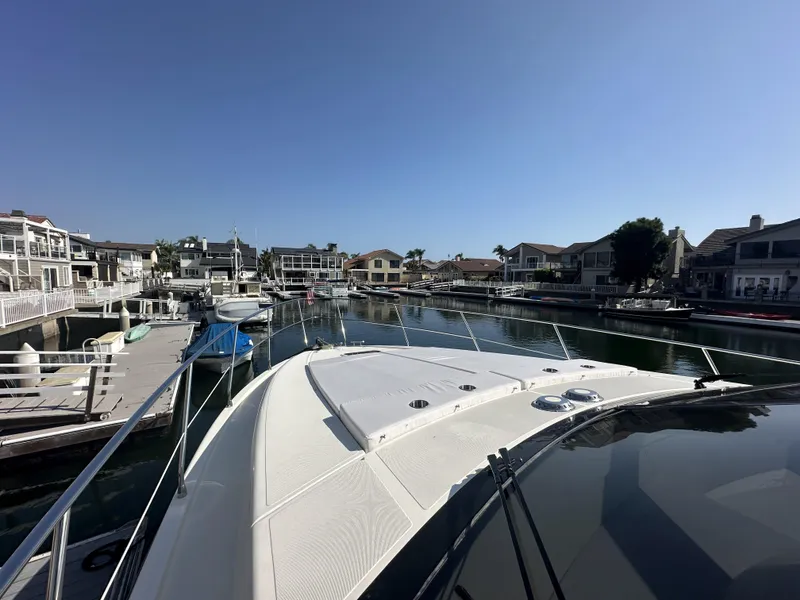 Slide: The Image of 1996 Azimut 54 yacht docked in a serene marina with waterfront homes. - 27