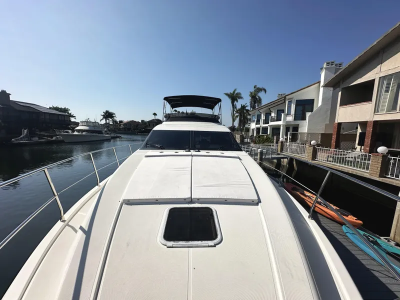 Slide: The Image of 1996 Azimut 54 yacht docked in a sunny marina with waterfront homes. - 28