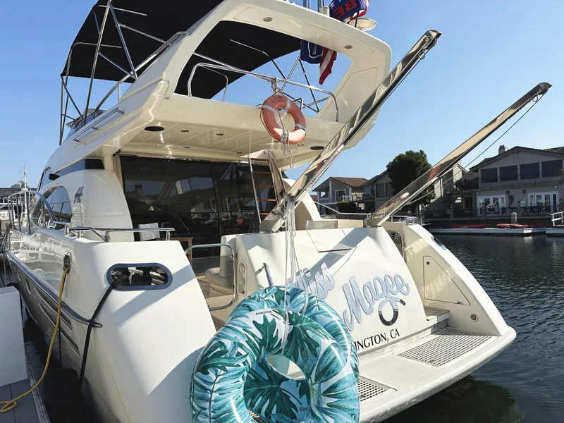 Slide: The Image of 1996 Azimut 54 yacht docked, featuring a spacious deck and tropical-themed life ring. - 29