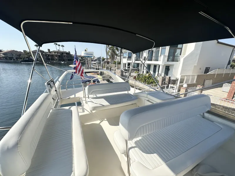 Slide: The Image of Flybridge of 1996 Azimut 54 yacht with seating, docked by waterfront homes. - 31