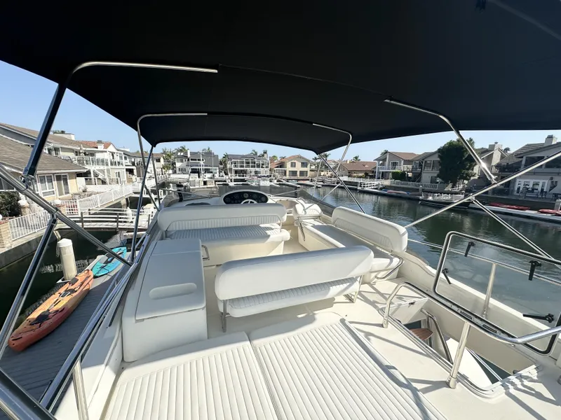 Slide: The Image of 1996 Azimut 54 yacht with spacious deck, docked in a scenic marina. - 32