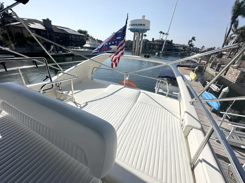 Slide: The Image of 1996 Azimut 54 yacht with American flag, docked in a marina, sunny day. - 33