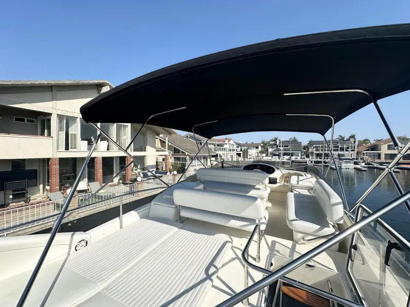 Slide: The Image of 1996 Azimut 54 yacht with spacious deck and canopy, docked in a marina. - 38