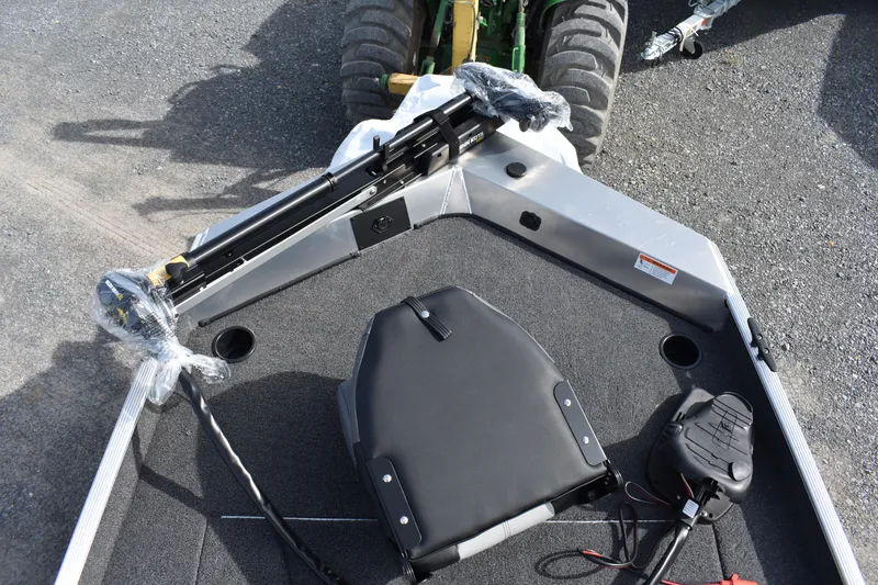 Slide: The Image of 2025 Crestliner 1700 Storm boat interior with seating and equipment on a gravel surface. - 5