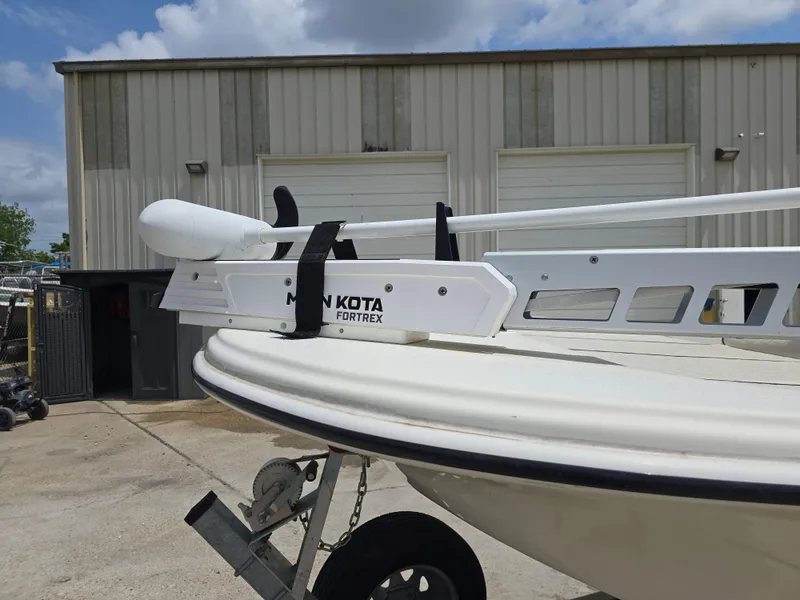 Slide: The Image of 2021 Carolina Skiff 21 LS with Minn Kota Fortrex trolling motor, parked outside a garage. - 12