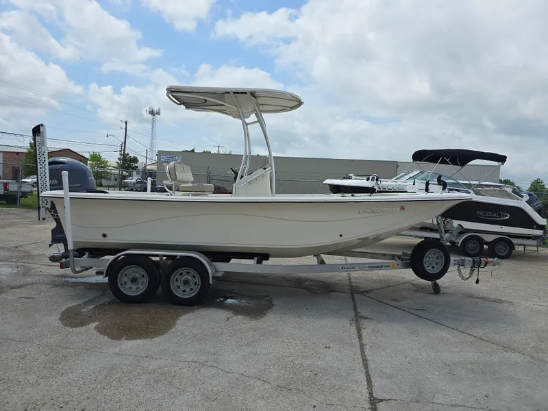 Slide: The Image of 2021 Carolina Skiff 21 LS boat on trailer, parked outdoors under cloudy sky. - 13