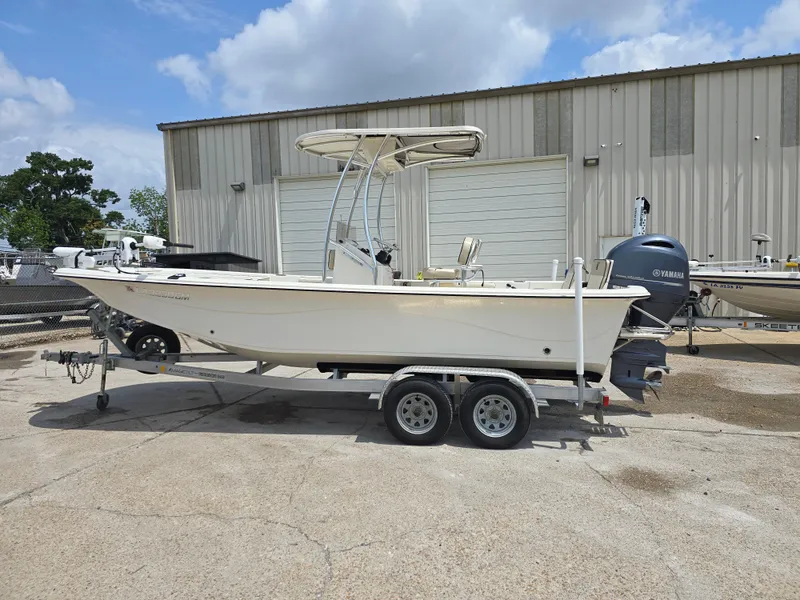 Slide: The Image of 2021 Carolina Skiff 21 LS boat on trailer, parked outside a warehouse. - 2