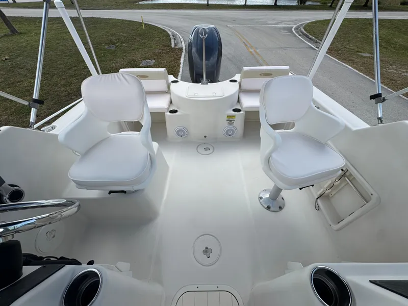 Slide: The Image of 2011 Cobia 215 Dual Console boat interior with white seating and steering wheel. - 11