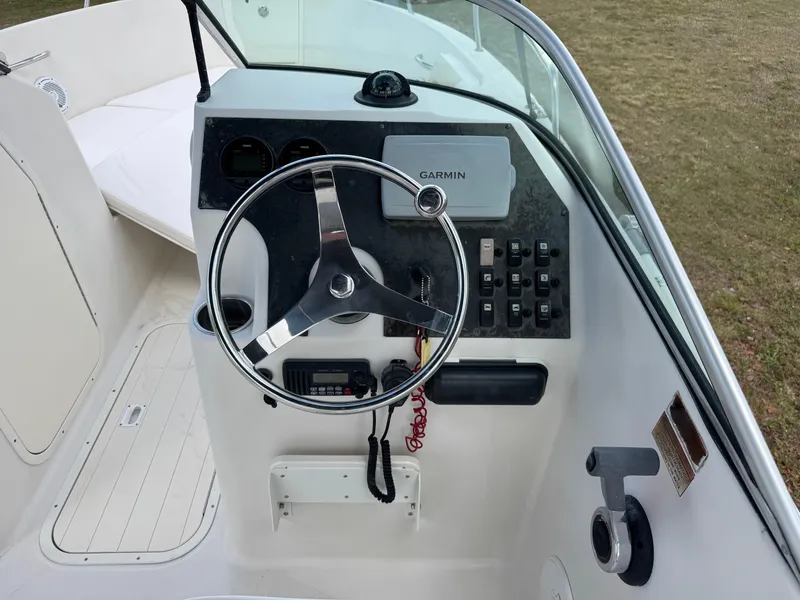Slide: The Image of 2011 Cobia 215 Dual Console boat dashboard with steering wheel and Garmin navigation system. - 14