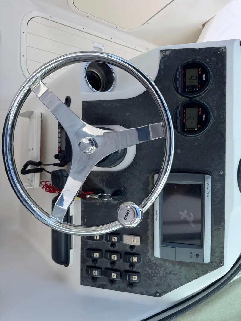 Slide: The Image of Steering wheel and dashboard of a 2011 Cobia 215 Dual Console boat. - 15