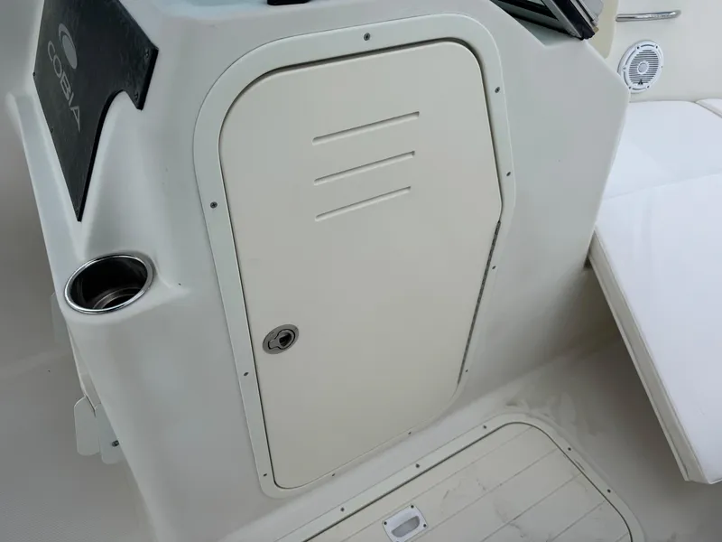 Slide: The Image of 2011 Cobia 215 Dual Console boat interior with storage compartment and cup holder. - 18