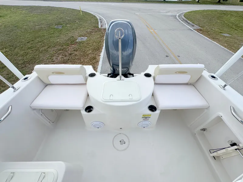 Slide: The Image of 2011 Cobia 215 Dual Console boat interior with seating and motor view. - 22
