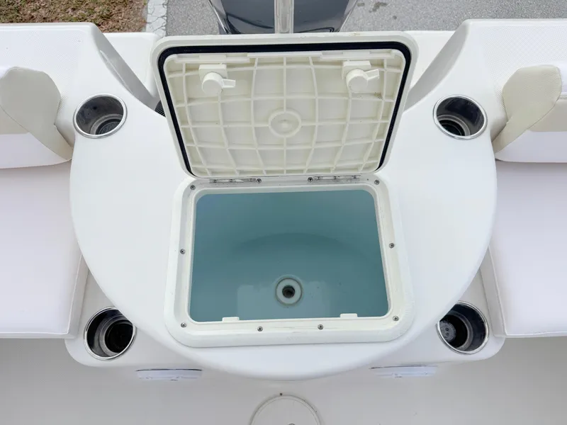 Slide: The Image of 2011 Cobia 215 Dual Console boat with open storage compartment and cup holders. - 25