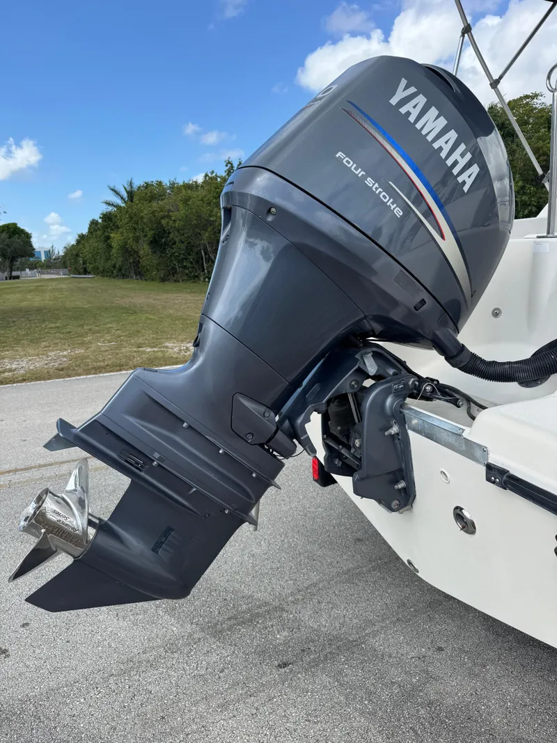 Slide: The Image of 2011 Cobia 215 Dual Console with Yamaha outboard motor, parked on a sunny day. - 30