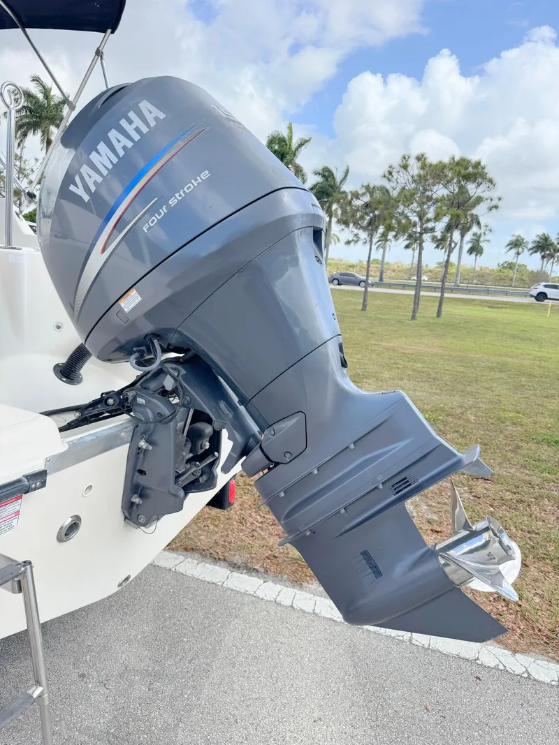 Slide: The Image of 2011 Cobia 215 Dual Console with Yamaha outboard motor, parked outdoors. - 31