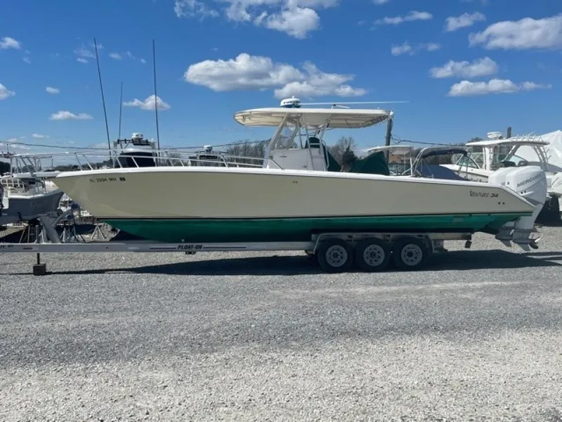 Slide: The Image of 2000 Venture 34 Center Console boat on trailer, parked outdoors under blue sky. - 0