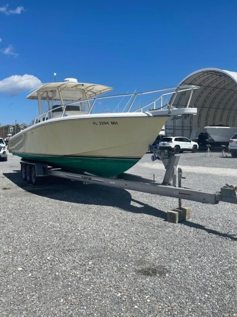Slide: The Image of 2000 Venture 34 Center Console boat on trailer, parked outdoors under clear blue sky. - 1