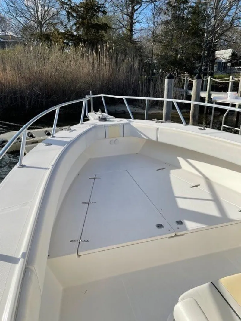 Slide: The Image of 2000 Venture 34 Center Console boat with spacious deck, docked near reeds and trees. - 10
