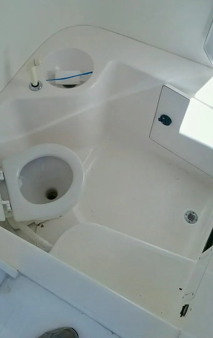 Slide: The Image of 2000 Venture 34 Center Console boat interior with compact bathroom amenities. - 14