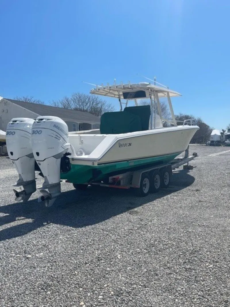 Slide: The Image of 2000 Venture 34 Center Console boat on trailer with dual engines, parked outdoors. - 22