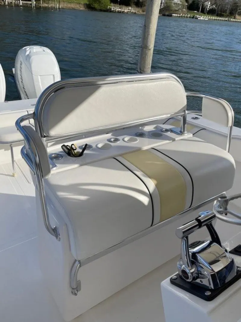 Slide: The Image of 2000 Venture 34 Center Console boat seat with rod holders, near water. - 7