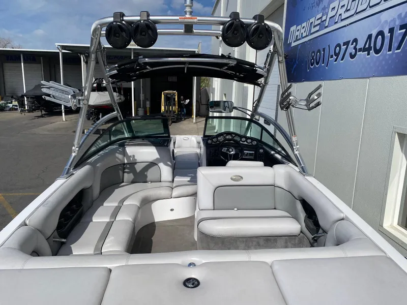 Slide: The Image of 2006 Supra Launch 24 SSV boat interior with seating and speakers, docked near a marine shop. - 5