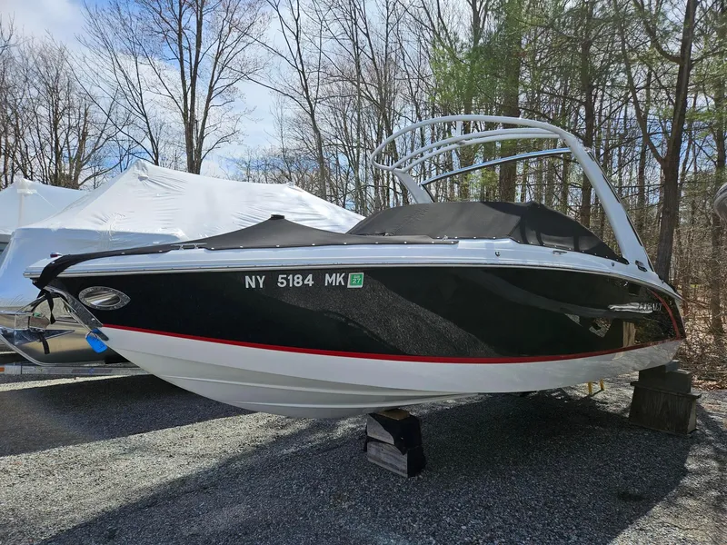 Slide: The Image of 2015 Cobalt R3 boat on display, black and white hull, parked outdoors. - 1