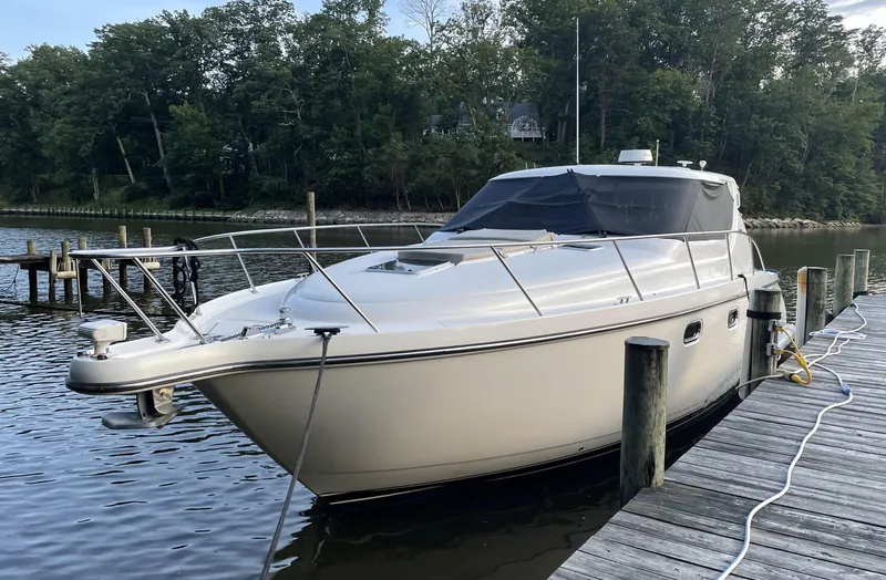 Slide: The Image of 2006 Tiara Yachts 4300 Sovran docked by a wooded shoreline. - 0