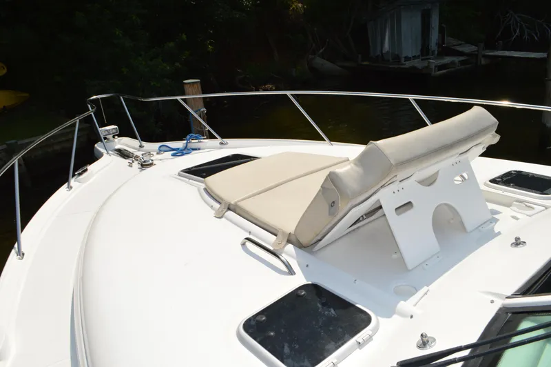 Slide: The Image of 2006 Tiara Yachts 4300 Sovran deck with sunbed and railing, docked near water. - 13