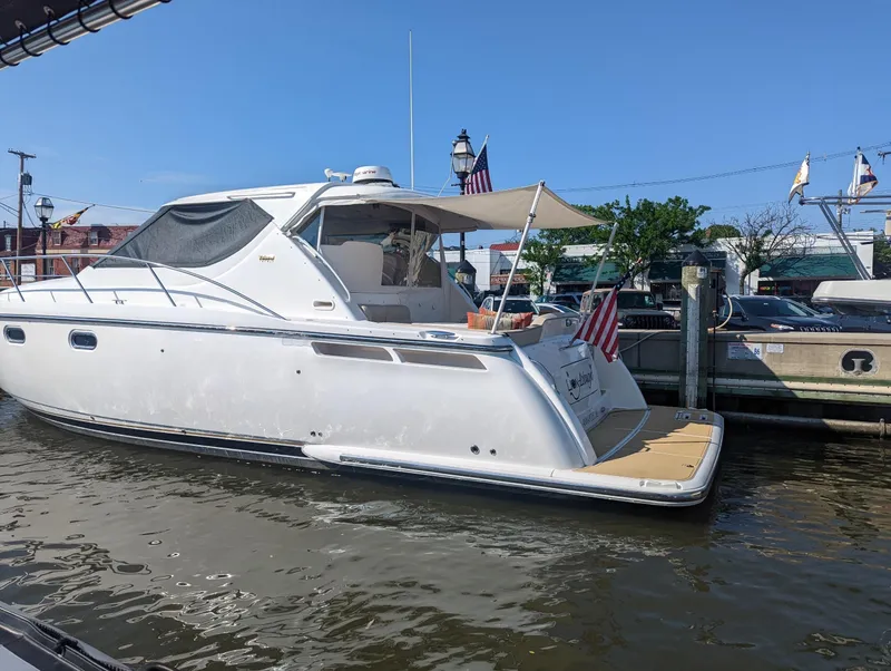 Slide: The Image of 2006 Tiara Yachts 4300 Sovran docked, featuring sleek design and American flags. - 2