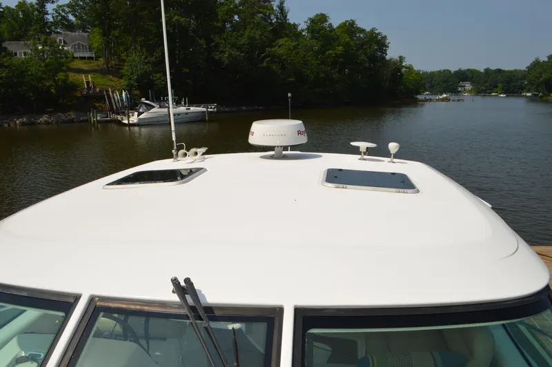 Slide: The Image of 2006 Tiara Yachts 4300 Sovran on a serene river with lush greenery. - 24