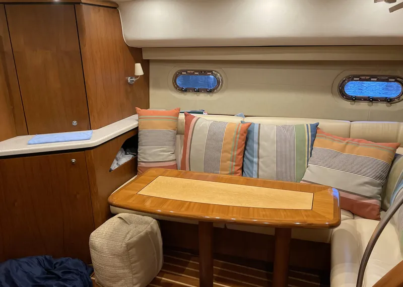 Slide: The Image of 2006 Tiara Yachts 4300 Sovran interior with striped cushions and wooden table. - 48