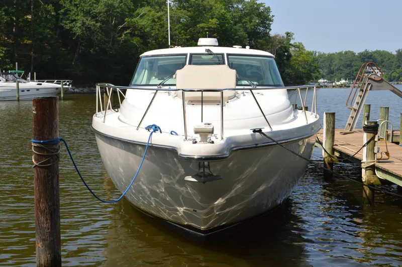 Slide: The Image of 2006 Tiara Yachts 4300 Sovran docked on a calm lake with lush greenery. - 5