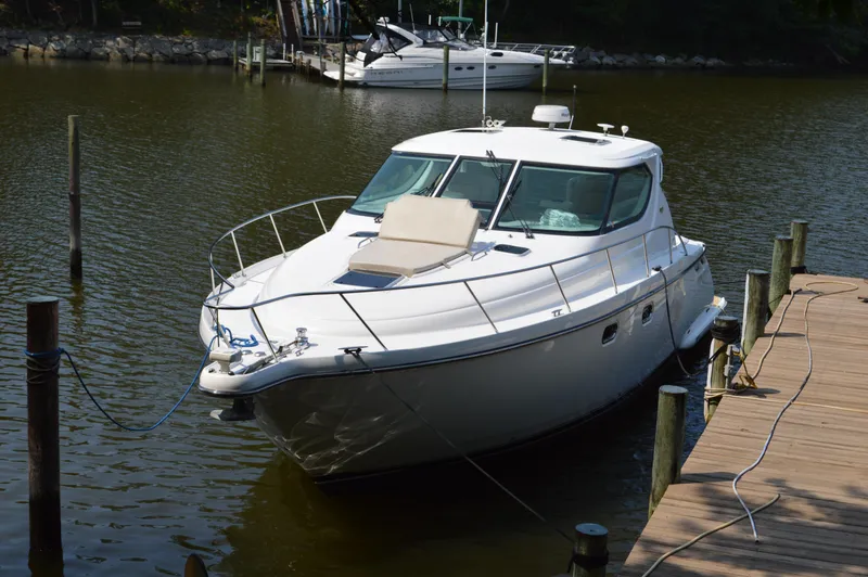 Slide: The Image of 2006 Tiara Yachts 4300 Sovran docked in a serene marina setting. - 6