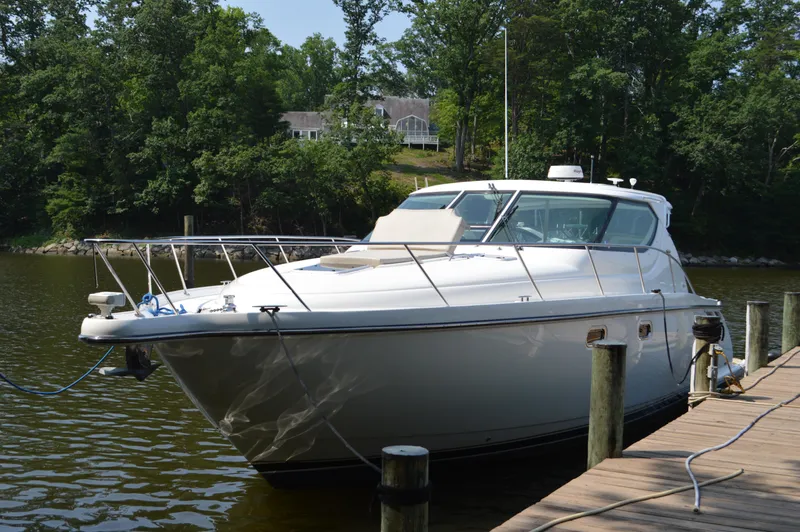 Slide: The Image of 2006 Tiara Yachts 4300 Sovran docked by a serene lakeside with lush greenery. - 8