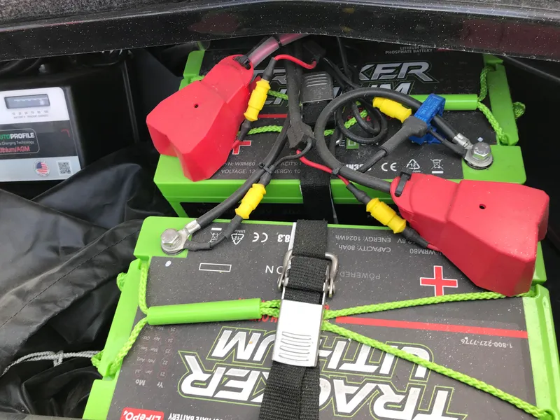 Slide: The Image of 2023 Ranger Z520R boat batteries with red and yellow connectors, secured with straps. - 37
