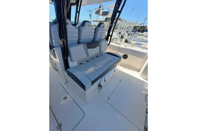 Slide: The Image of 2025 Robalo R300 Center Console boat interior with cushioned seating and storage compartments. - 18