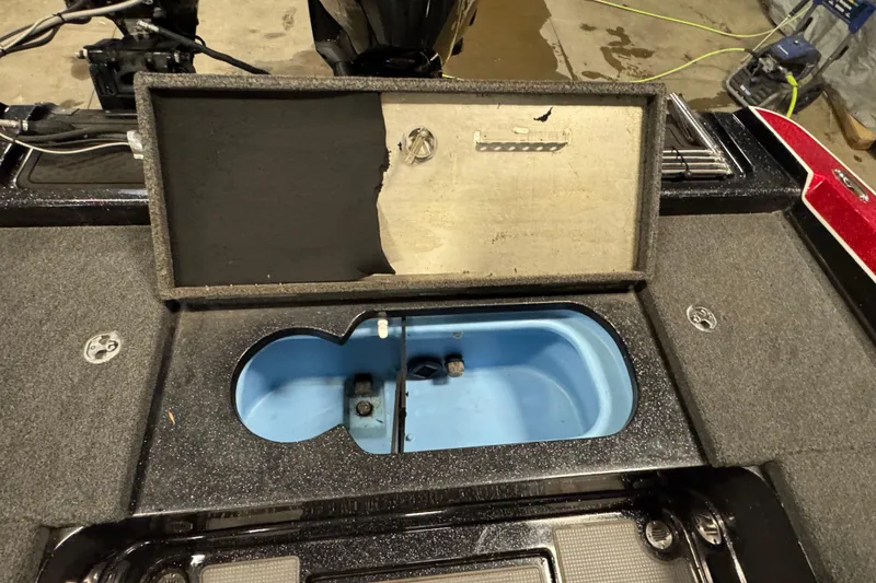 Slide: The Image of Open storage compartment on 2022 Nitro ZV20 boat, featuring a blue interior. - 13