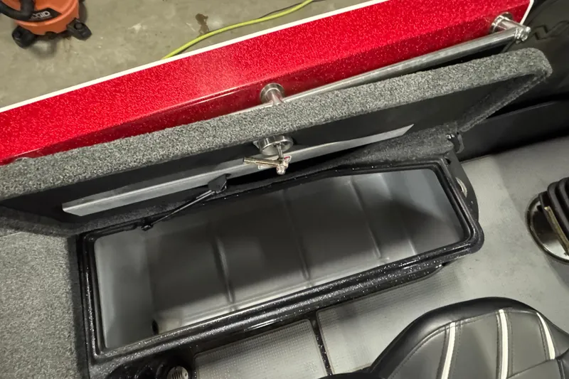Slide: The Image of Open storage compartment in 2022 Nitro ZV20 boat, featuring red and gray interior. - 14