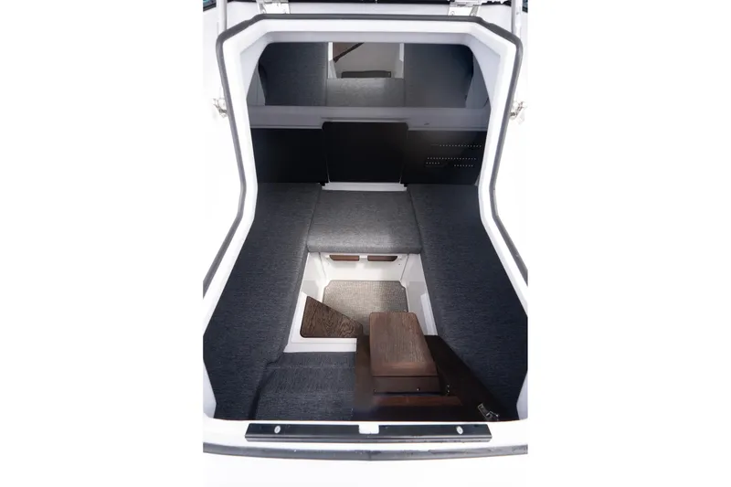 Slide: The Image of 2026 Axopar 29 XC Cross Cabin interior with cushioned seating and wooden paneling. - 22
