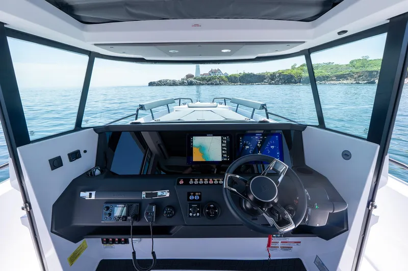 Slide: The Image of 2026 Axopar 29 XC Cross Cabin boat on calm water, rear view with dual engines. - 39