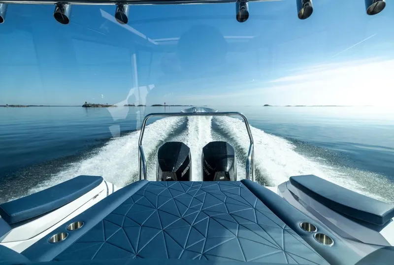 Slide: The Image of 2026 Axopar 29 XC Cross Cabin interior with dual seats and steering wheel in a showroom. - 5