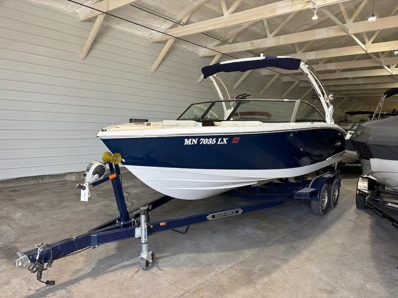 Slide: The Image of 2019 Cobalt CS23 Surf boat on trailer in indoor storage. - 2