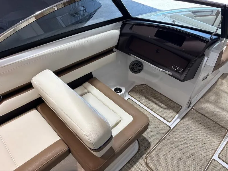 Slide: The Image of 2019 Cobalt CS23 Surf boat interior with beige and brown seating, dashboard, and speaker. - 6