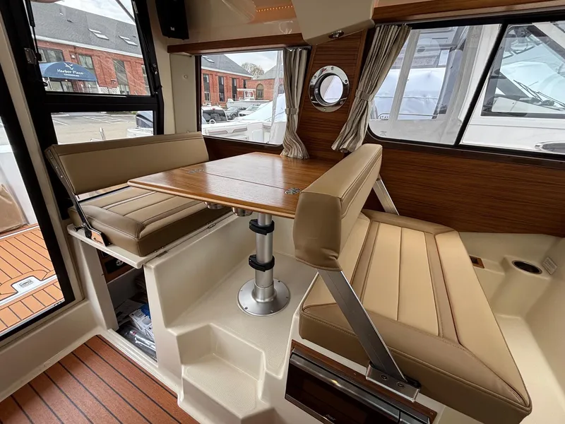 Slide: The Image of Interior of 2025 Ranger Tugs R-25, featuring a cozy dining area with wood accents. - 10