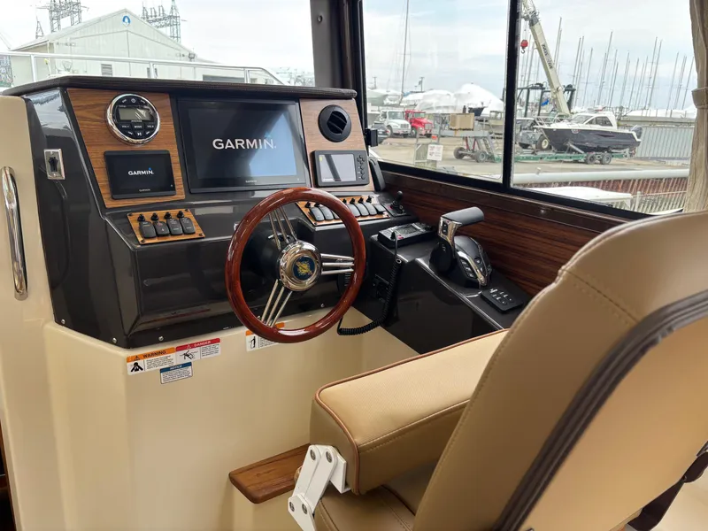 Slide: The Image of 2025 Ranger Tugs R-25 helm with Garmin navigation, wood accents, and comfortable seating. - 5