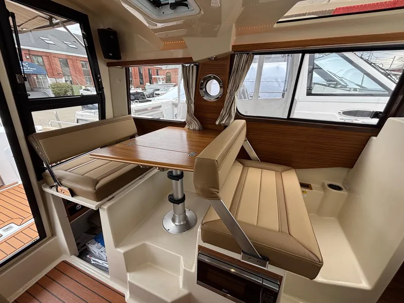 Slide: The Image of 2025 Ranger Tugs R-25 interior with seating, table, and windows, showcasing modern design. - 8