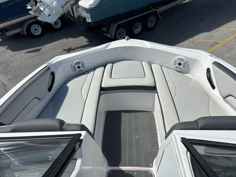 Slide: The Image of 2022 Yamaha Boats SX190 interior with gray seating and speakers, parked on a trailer. - 12