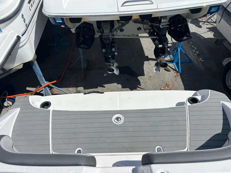 Slide: The Image of 2022 Yamaha Boats SX190 swim platform with dual engines, docked on a sunny day. - 14