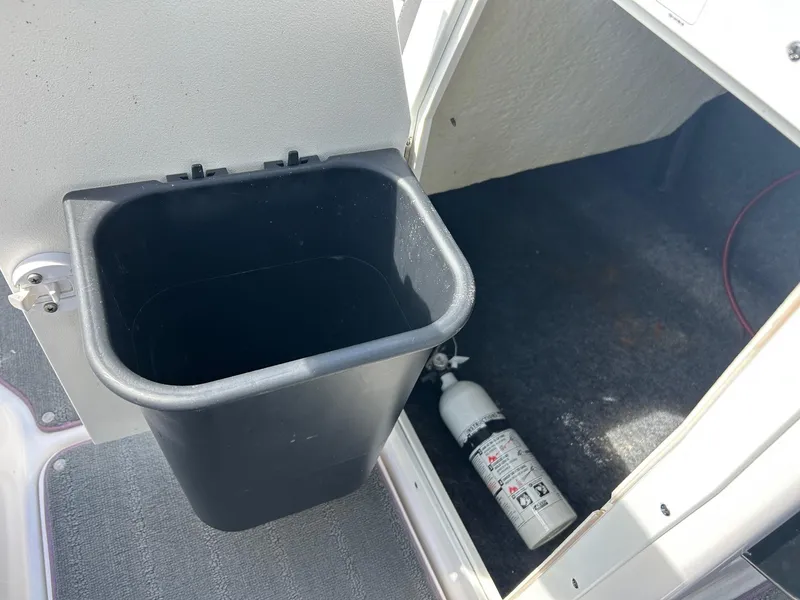 Slide: The Image of 2022 Yamaha SX190 boat storage area with trash bin and fire extinguisher. - 17